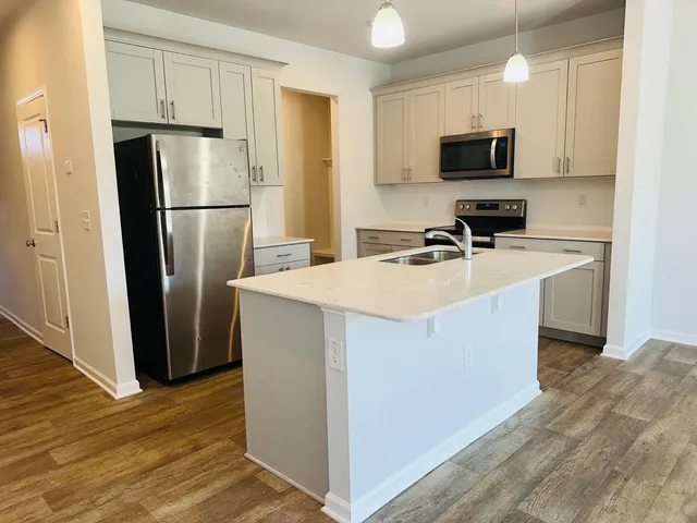 a kitchen with stainless steel appliances a refrigerator stove microwave and sink