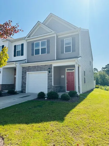 a view of a yard in front of a house with a large tree