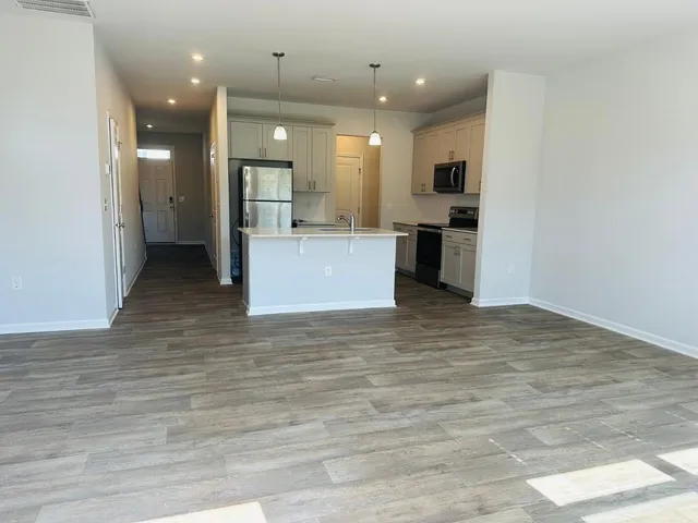 a view of kitchen with kitchen island white cabinets and refrigerator