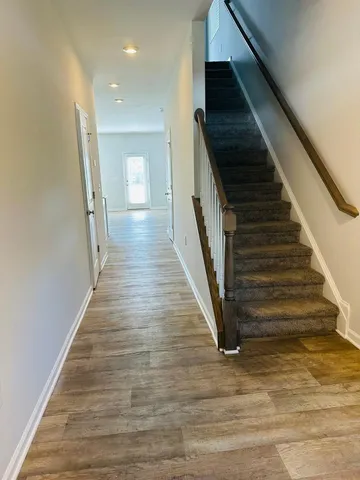 a view of staircase with wooden floor and white walls