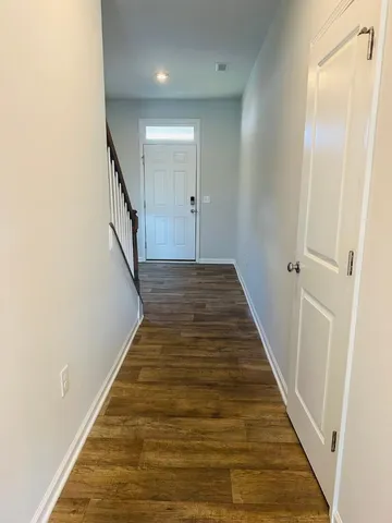 a view of a hallway with wooden floor and staircase