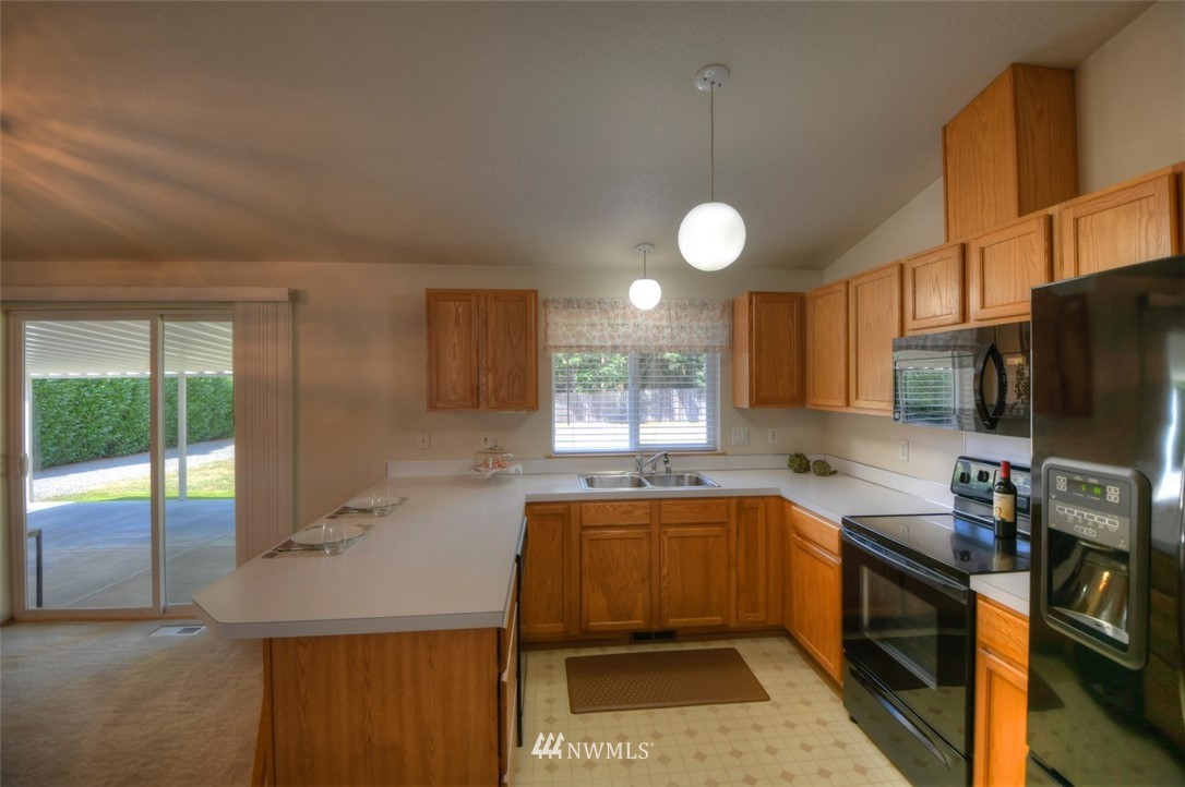 5436 187th Court Southwest Rochester, WA 98579 - Photo 10 of 25 a kitchen with a sink stainless steel appliances and cabinets