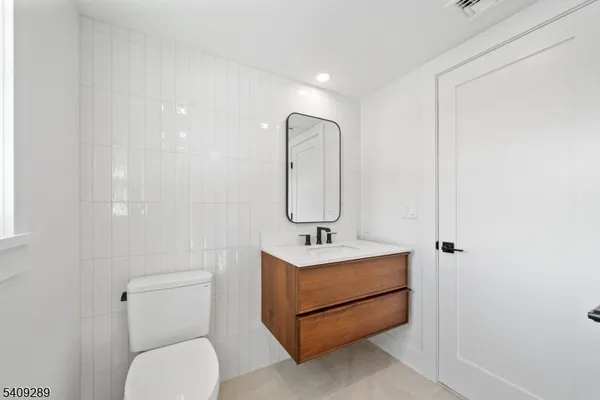 a bathroom with a sink toilet and mirror