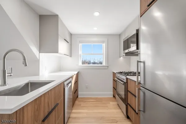 a kitchen with stainless steel appliances granite countertop a sink and a stove top oven