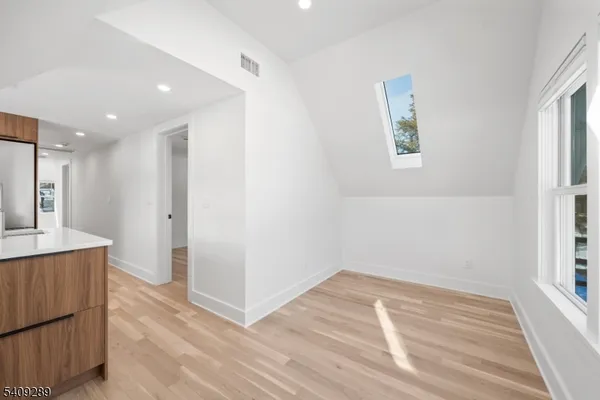 a view of a kitchen with wooden floor and a window