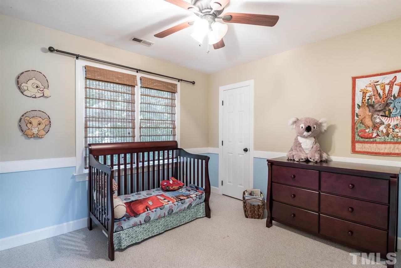 2612 Dahlgreen Road Raleigh, NC 27615 - Photo 18 of 25 a bedroom with a bed and a chandelier