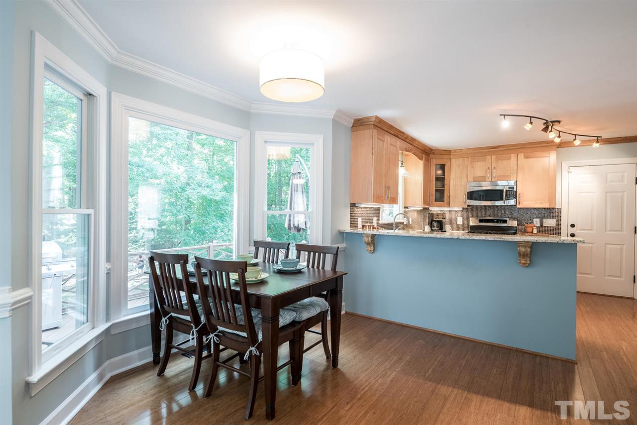 2612 Dahlgreen Road Raleigh, NC 27615 - Photo 10 of 25 a kitchen with stainless steel appliances granite countertop a stove a refrigerator a microwave oven with a dining table and chairs with wooden floor