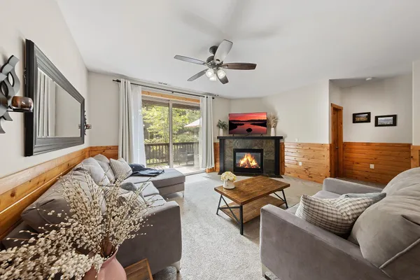 a living room with furniture fireplace and a large window