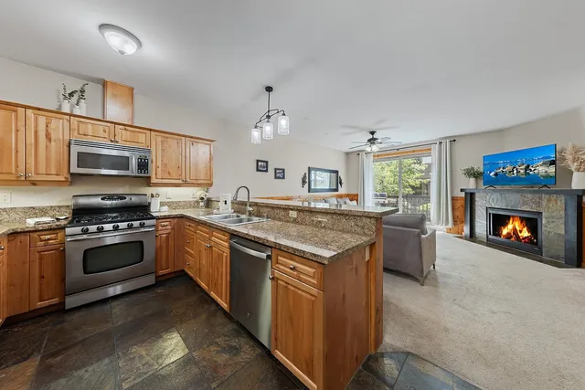 a kitchen with stainless steel appliances granite countertop a stove top oven a sink and a microwave