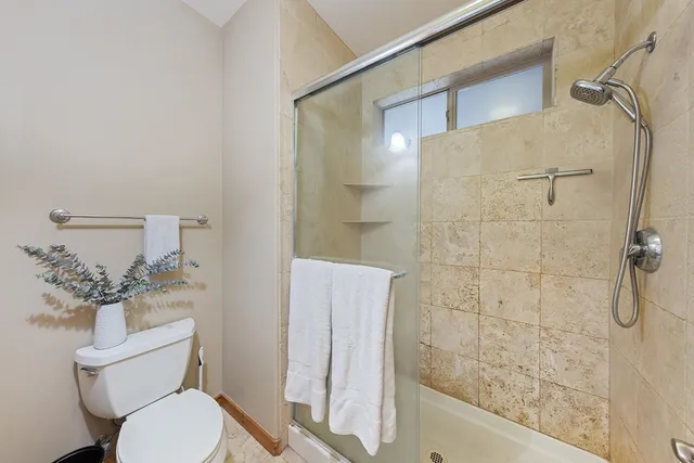 a bathroom with a toilet and a shower