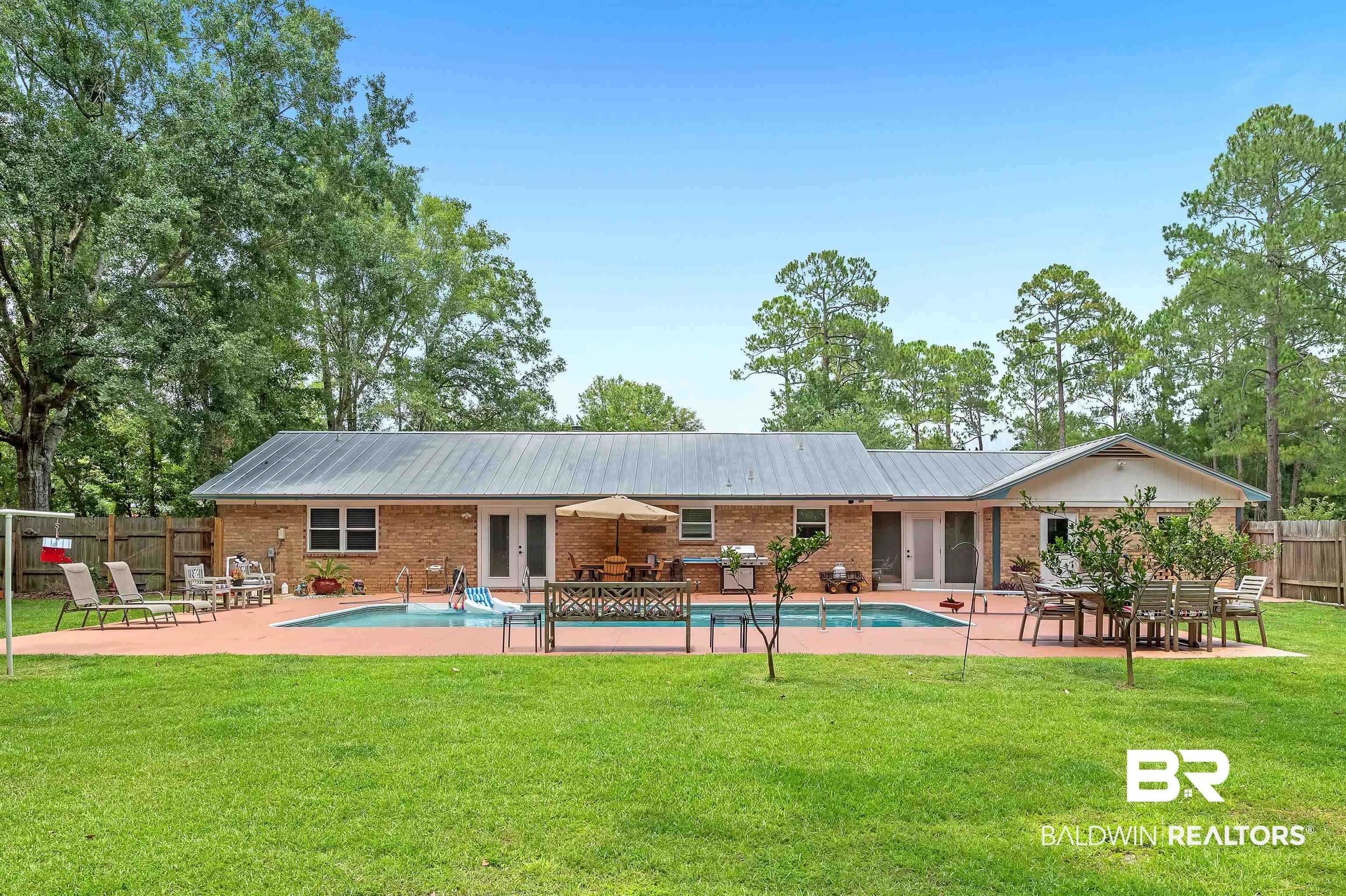 24551 Wolf Bay Drive Foley, AL 36535 - Photo 15 of 59 Back of property with french doors, a patio area, brick siding, and a metal roof