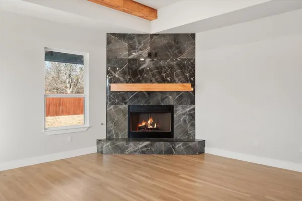 a view of an empty room with a fireplace and a window