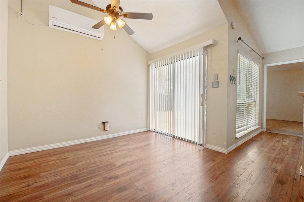 7305 Pineberry Road Dallas, TX 75249 - Photo 7 of 25 an empty room with wooden floor fan and windows