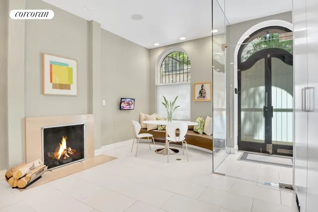a living room with furniture a fireplace and a floor to ceiling window