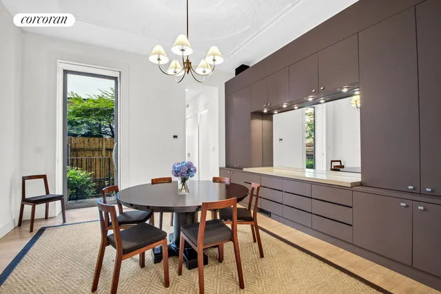 a dining room with wooden floor a chandelier a wooden table and chairs