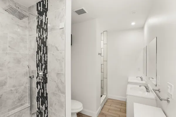a bathroom with a sink a toilet and shower