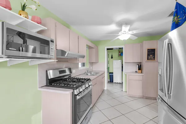 a kitchen with stainless steel appliances granite countertop a refrigerator a stove and a sink with cabinets