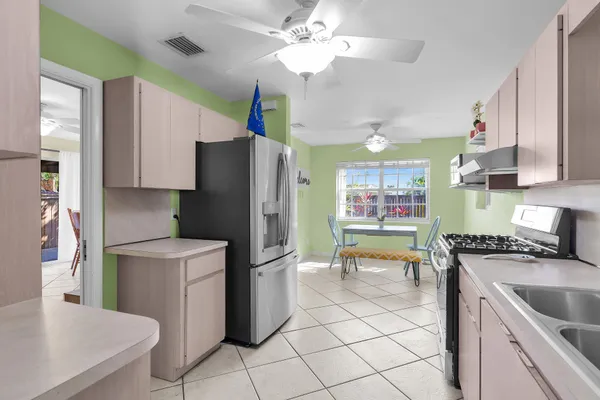 a kitchen with stainless steel appliances granite countertop a refrigerator a sink a stove and dishwasher