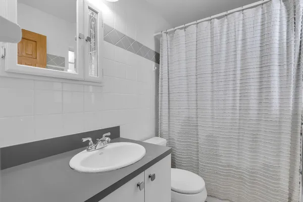 a bathroom with a sink vanity and toilet
