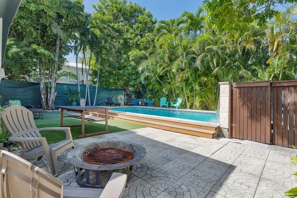 a view of a swimming pool with a patio and a yard