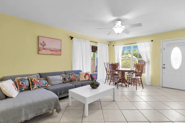 a living room with furniture a dining table and a window