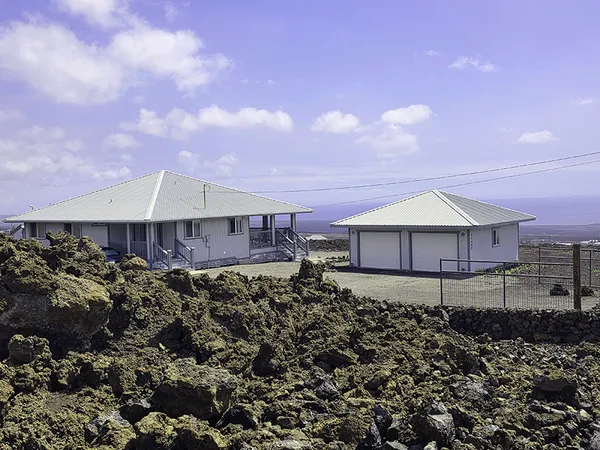 a view of a house with a yard and sitting area