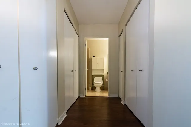 a bathroom with a granite countertop toilet sink and mirror