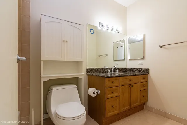 a bathroom with a granite countertop toilet sink and shower