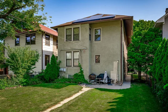 a view of a house with a big yard and large trees