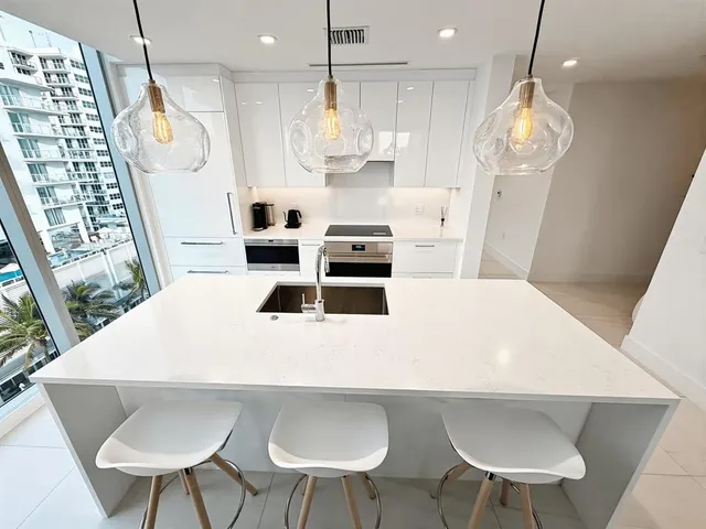 a kitchen with stainless steel appliances a table chairs and wooden floor