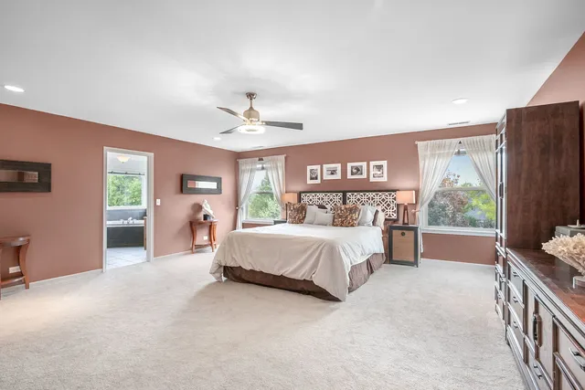 a spacious bedroom with a bed and a chandelier