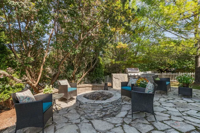 a view of a backyard with table and chairs potted plants and tree