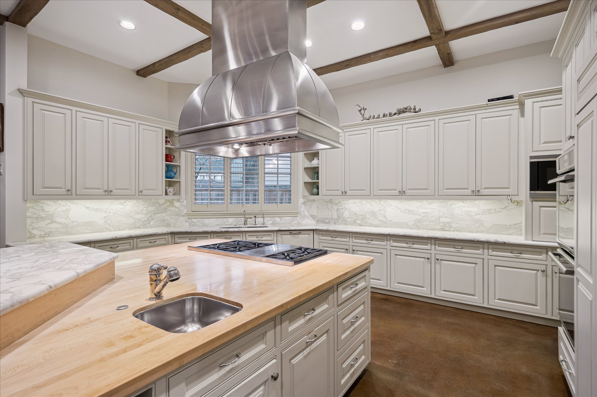 3109 Locke Lane Houston, TX 77019 - Photo 13 of 50 Custom cabinetry, soft-closing drawers, and dedicated pot and pan storage highlight the kitchen’s exceptional functionality. The spacious island with breakfast bar overlooks adjoining living spaces, while recessed lighting and neutral tones keep the atmosphere bright and welcoming. A walk-in pantry, butler’s pantry, and premium appliances provide everything needed for elevated everyday living.