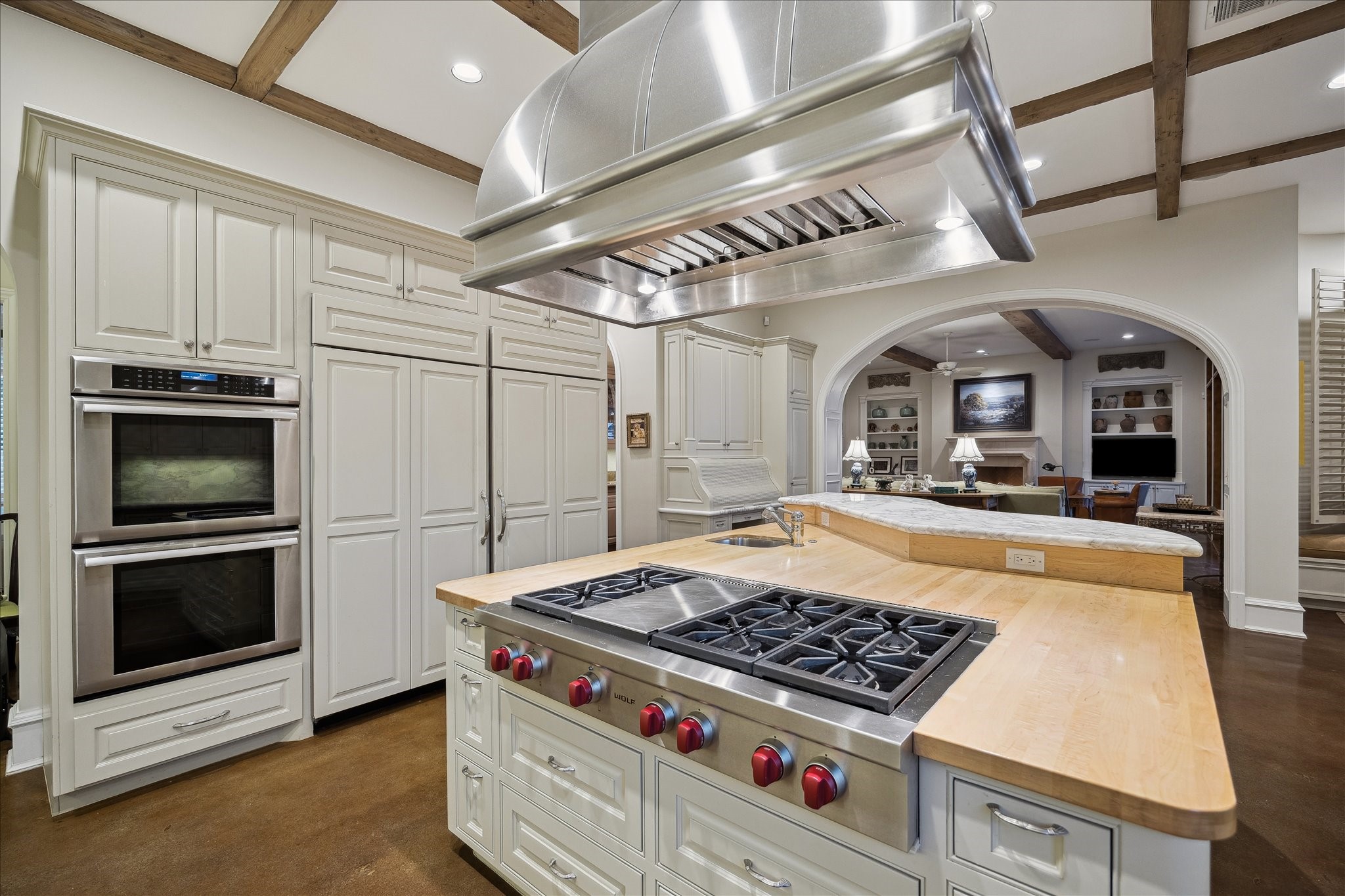 3109 Locke Lane Houston, TX 77019 - Photo 15 of 50 This thoughtfully designed kitchen blends beauty and function with neutral designer paint, recessed lighting, and expansive marble surfaces. Custom cabinetry features soft-closing drawers, dedicated cookware storage, and generous pantry space with both a butler’s pantry and walk-in pantry. Two KitchenAid sinks, a Wolf gas cooktop with Lone Star range hood, and double ovens elevate the space for effortless entertaining.