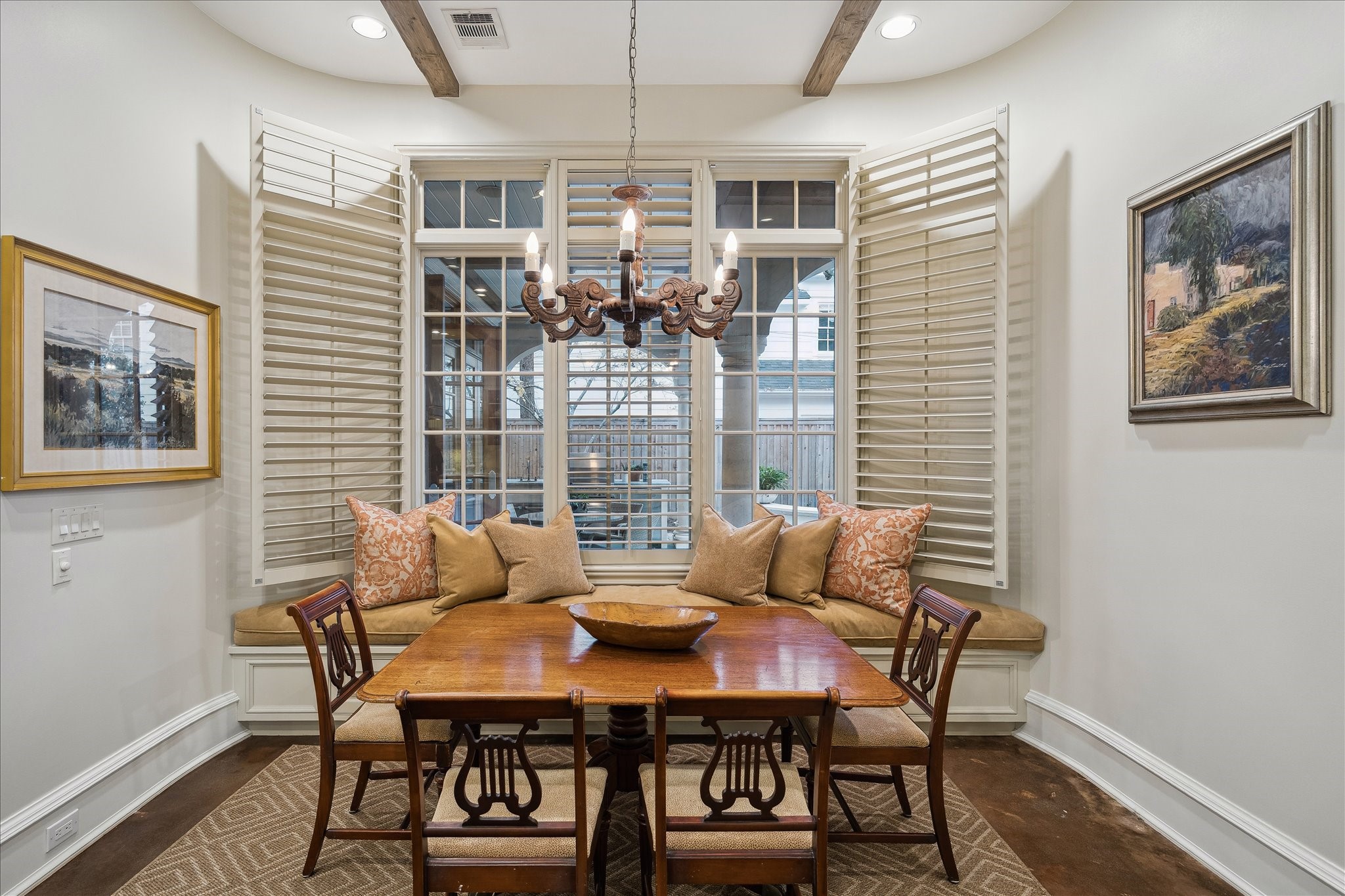 3109 Locke Lane Houston, TX 77019 - Photo 17 of 50 Bathed in morning light from east-facing windows, this charming breakfast room offers built-in window seating and plantation shutters for a cozy yet refined feel. A designer chandelier and warm hardwood floors complete the space, perfectly positioned adjacent to the kitchen and living areas for effortless everyday living.