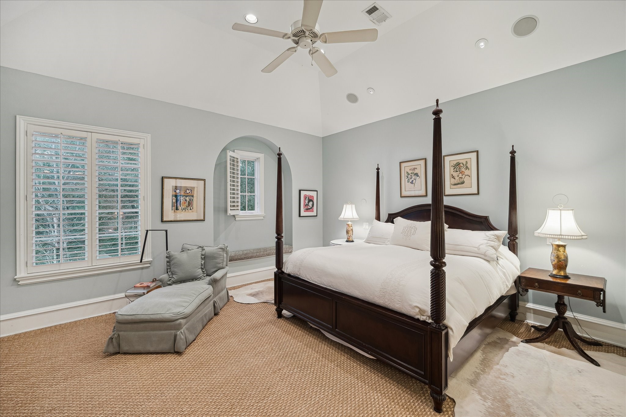 3109 Locke Lane Houston, TX 77019 - Photo 25 of 50 The primary bedroom is a luxurious retreat, featuring a cozy fireplace as its focal point and expansive windows that fill the space with natural light. A calming color palette with an inviting atmosphere, seamlessly connecting to the primary bathroom and closet for ultimate convenience and comfort.