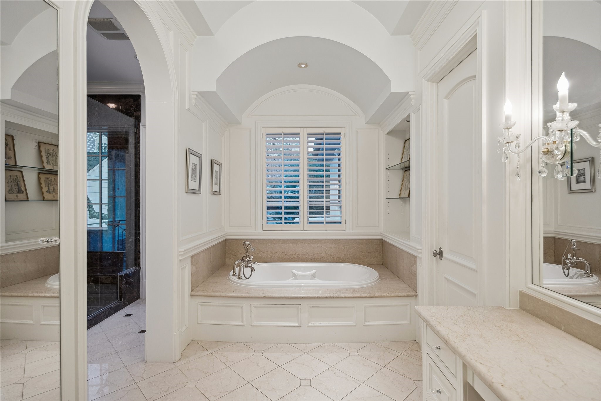 3109 Locke Lane Houston, TX 77019 - Photo 27 of 50 Thoughtfully appointed, Primary Bathroom features marble surfaces, tile flooring, and a spacious walk-in shower and soaking tub. Relax in the spa-like soaking tub, beautifully framed with a tiled surround and positioned to enjoy natural light from the window with plantation shutters.