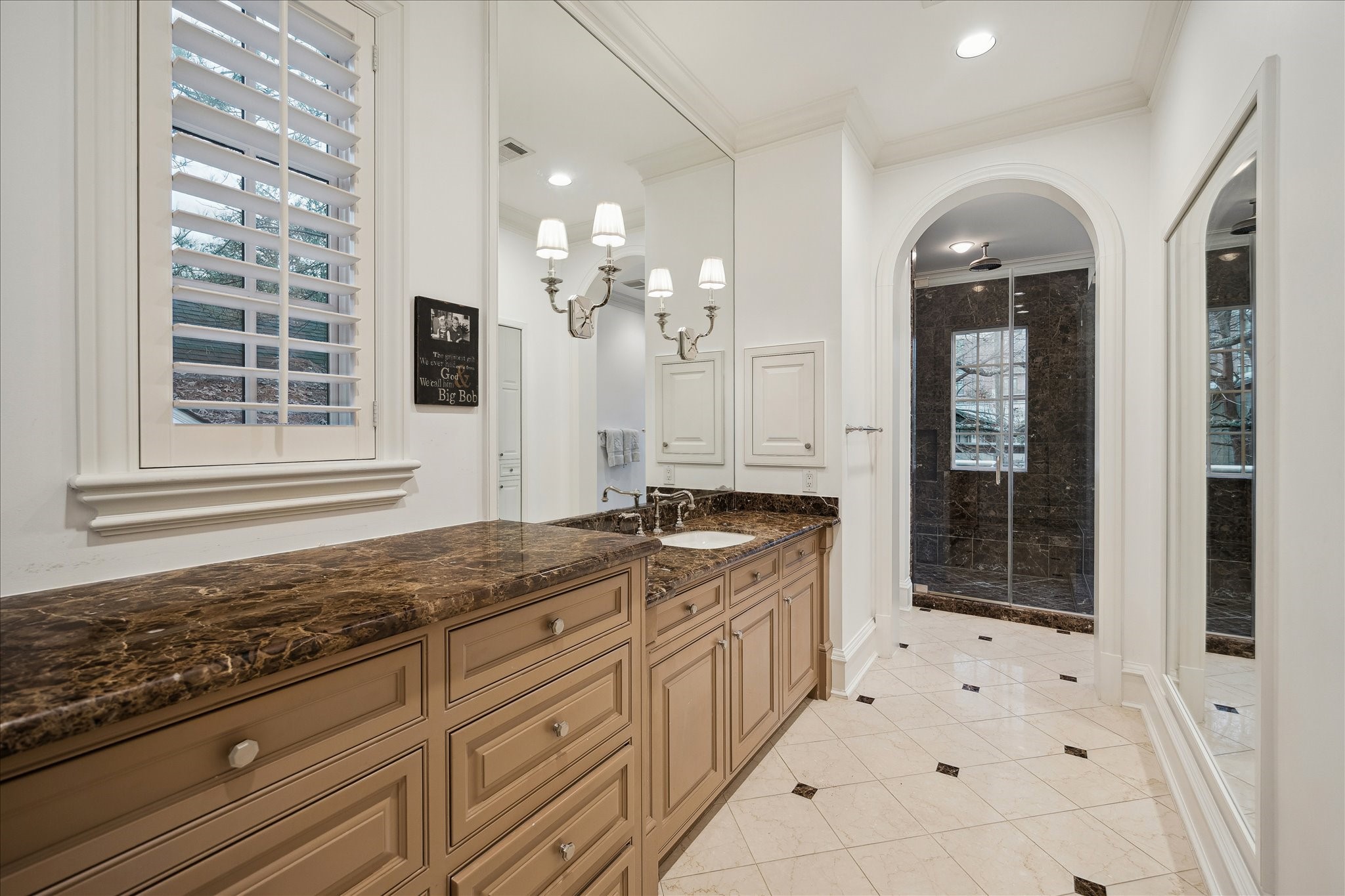 3109 Locke Lane Houston, TX 77019 - Photo 29 of 50 Designed for luxury and function, the primary bathroom features tile flooring, marble countertops, and a custom vanity with seating. Light-filled and sophisticated, the space includes a soaking tub, full-height mirror, integrated chandelier and sconce lighting, and seamless access to the primary bedroom and Closet No. 1.