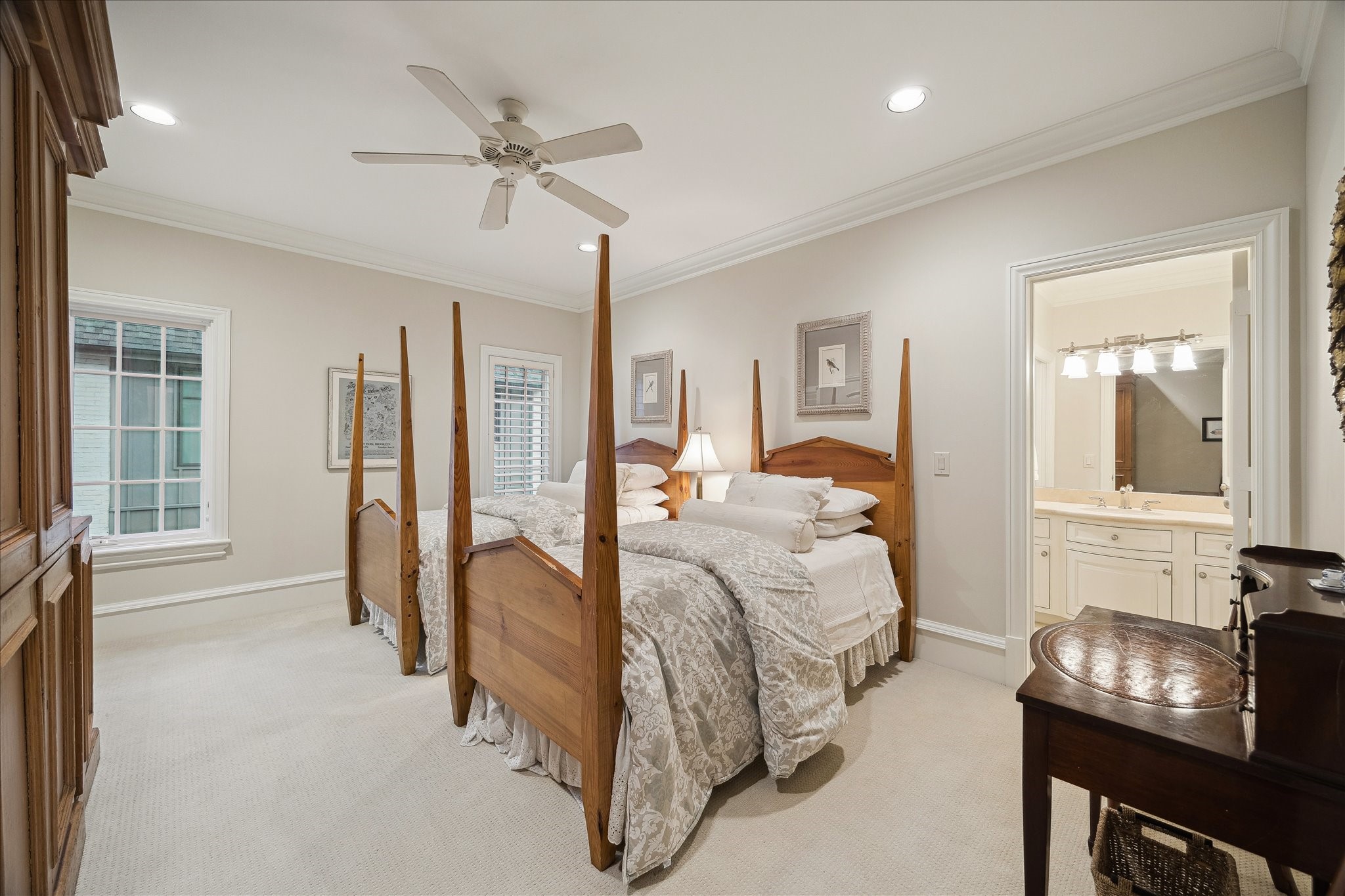 3109 Locke Lane Houston, TX 77019 - Photo 32 of 50 Guest Bedroom No. 2 is a bright and inviting retreat, featuring crown molding, a ceiling fan, recessed LED lighting, and plush carpeted floors. West-facing windows with plantation shutters fill the room with natural light, while a walk-in closet with built-in drawers, cabinetry, and hanging racks adds generous storage, plus dual access to the shared bathroom for convenience.