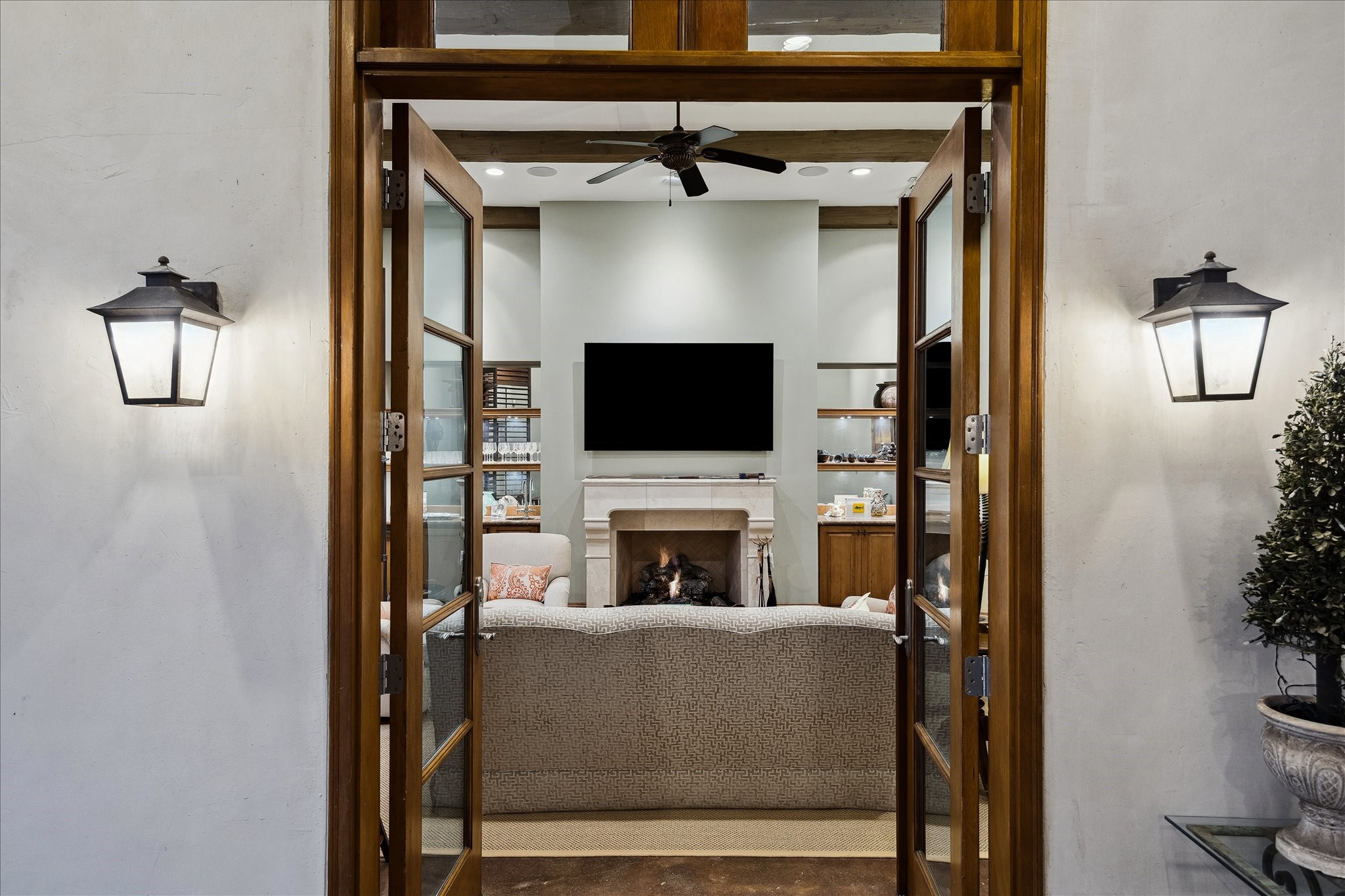 3109 Locke Lane Houston, TX 77019 - Photo 39 of 50 Elegant French doors open from the covered entryway into the detached game room, seamlessly connecting indoor and outdoor living while offering serene views of the pool. The design invites natural light and creates a bright, welcoming transition to this versatile space.