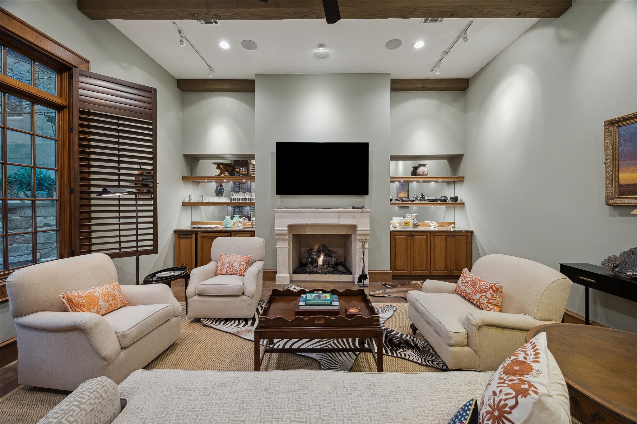 3109 Locke Lane Houston, TX 77019 - Photo 40 of 50 This detached first-floor game room/flex space offers a private retreat with rich wood paneling, exposed ceiling beams, and warm hardwood floors. A stone fireplace with custom mantel, built-in cabinetry, and media storage make it perfect for a game room, media room, or casual entertaining.