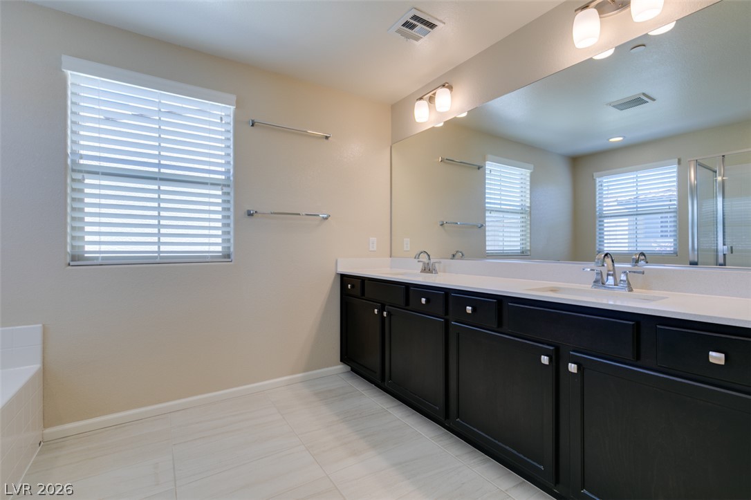 2549 Sable Ridge Street Henderson, NV 89044 - Photo 44 of 48 Dual vanities and a spacious mirror create a functional and pleasant bathroom.