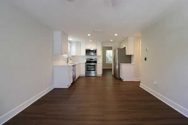 a view of kitchen with refrigerator stove microwave and cabinets