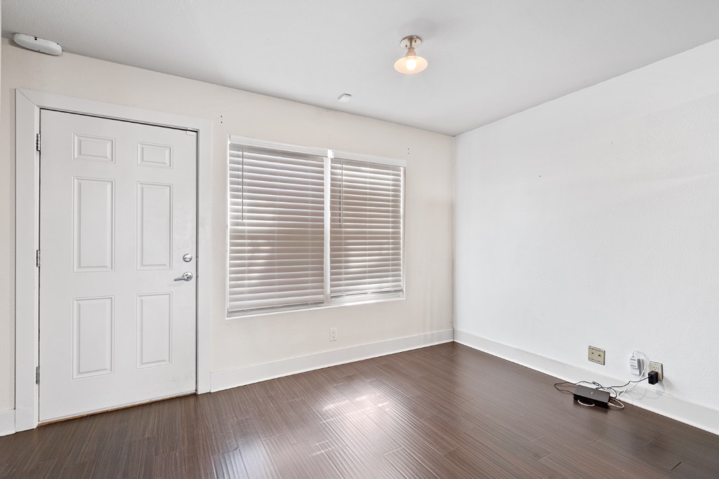 1101 Grove Boulevard, Unit 206 Austin, TX 78741 - Photo 11 of 23 an empty room with wooden floor and windows