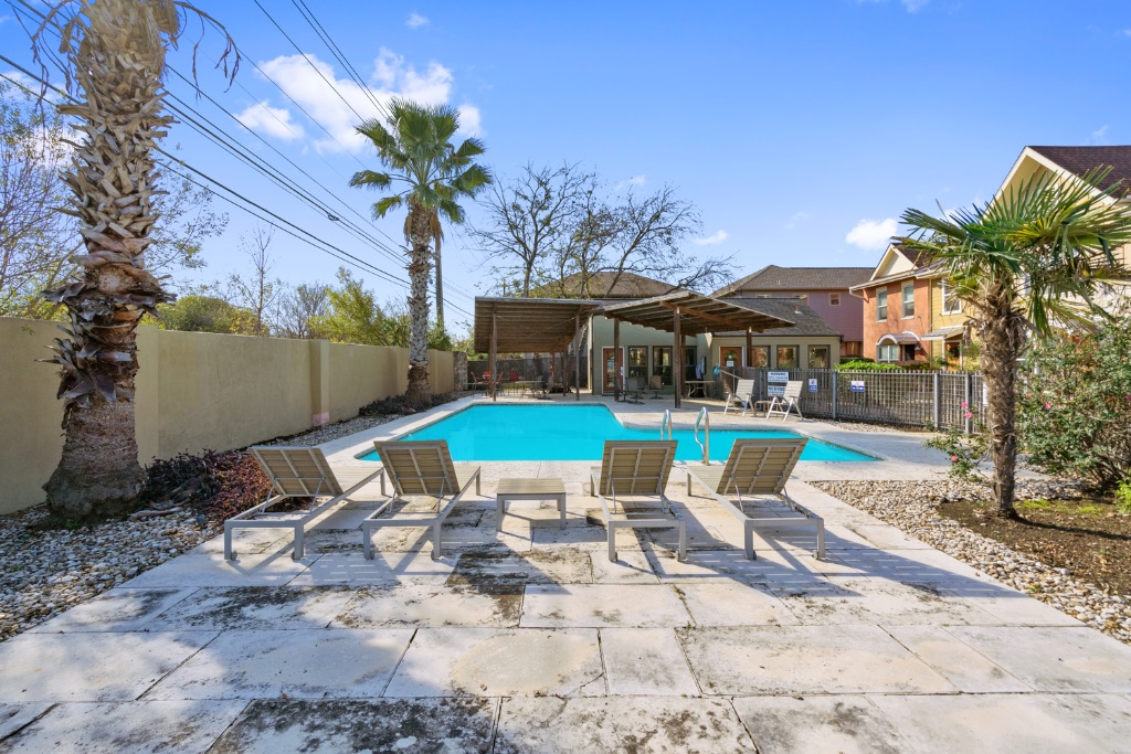 1101 Grove Boulevard, Unit 206 Austin, TX 78741 - Photo 18 of 23 a view of swimming pool with lawn chairs under an umbrella