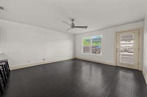 1101 Grove Boulevard, Unit 206 Austin, TX 78741 - Photo 8 of 23 an empty room with wooden floor chandelier fan and windows