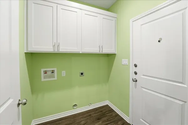 an empty room with wooden floor closet and windows