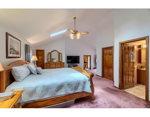 21 Bemis Road Pepperell, MA 01463 - Photo 21 of 27 a bedroom with a large bed and a chandelier