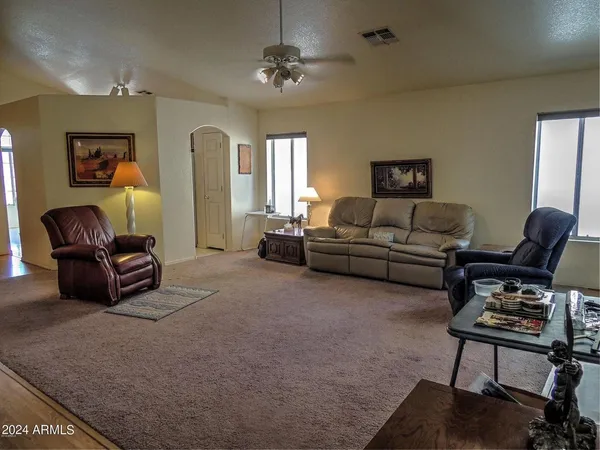 a living room with furniture a ceiling fan and a window