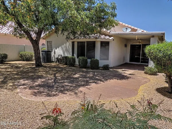 a front view of a house with a tree in front